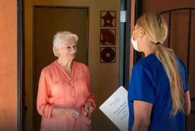 Woman greeting worker at doorway