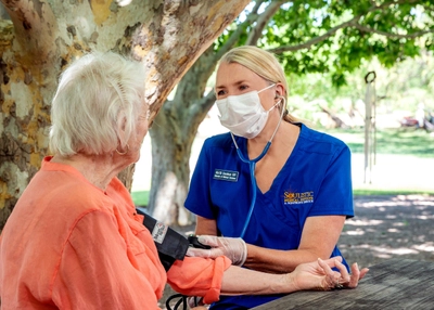 a nurse checking her hospice patient's bloodpressure