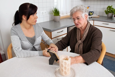 Woman supporting elderly woman