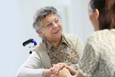 Woman supporting an elderly woman emotionally.